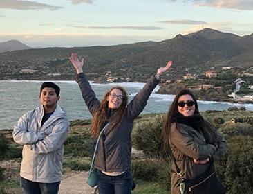 Students posing near mountains and the beach