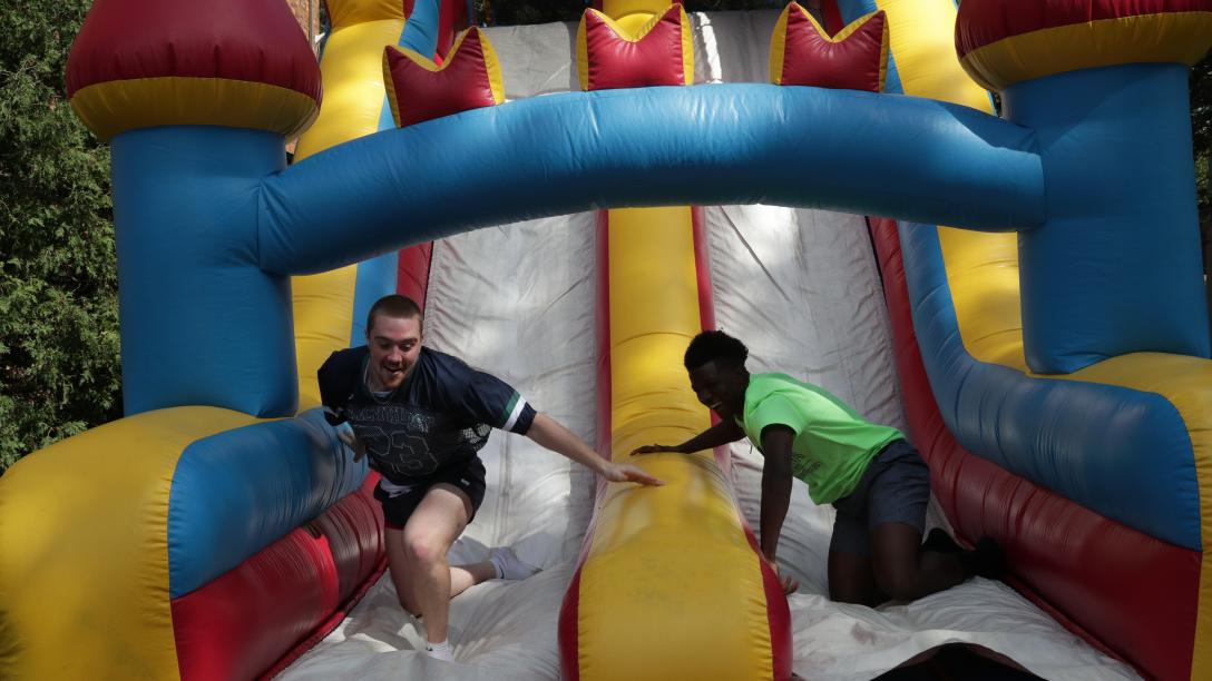 students on inflatable slide race